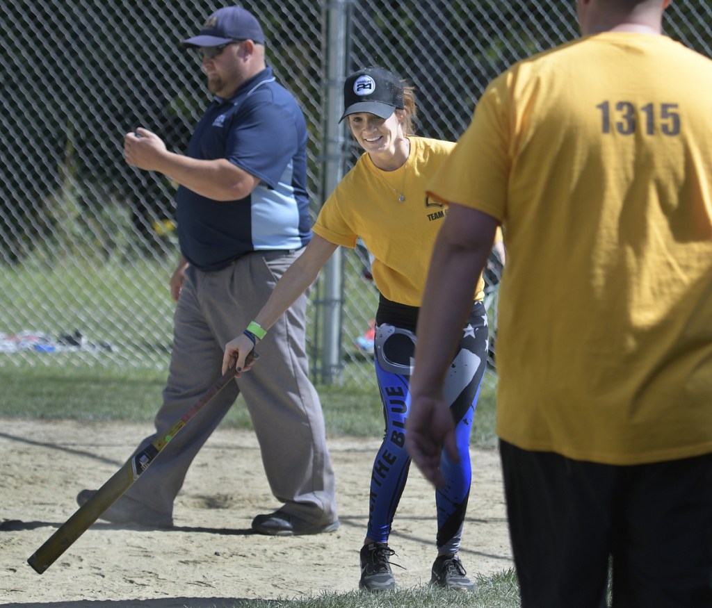 Jill Cole collects a bat Sunday after returning to home plate while playing for the Somerset County Sheriff's Department softball team at the Fraternal Order of Police tournament in Sidney. The fourth tournament was held in honor of Cole's father, Somerset Deputy Cpl. Eugene Cole, who lost his life in the line of duty April 25 in Norridgewock. The law enforcement union members fielded 12 teams, according to organizer Brittany Johnson, a detective with Kennebec County Sheriff's Office. All the money was donated to Cole's family.