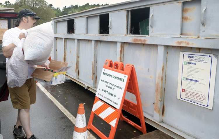 Stephen Mingo drops items into the recycling container behind the Buker Community Center on Thursday in Augusta.