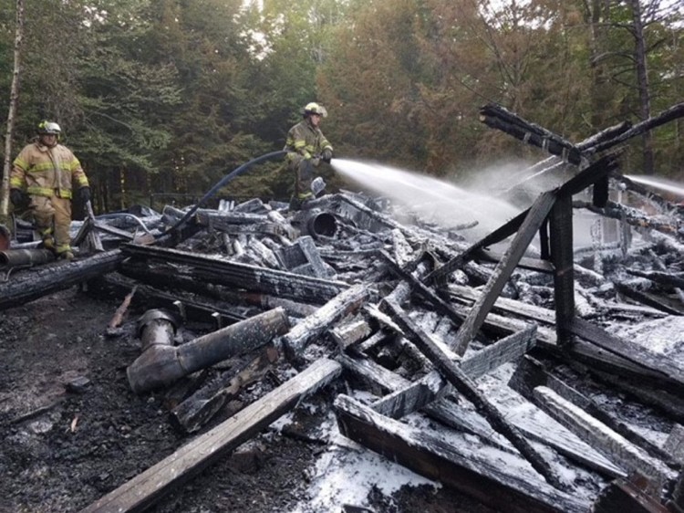 A log cabin camp on Hancock Pond in Embden that burned to the ground on Sunday, was started by a wood stove. No one was injured, but photographs of the family who has owned the camp for decades were destroyed.