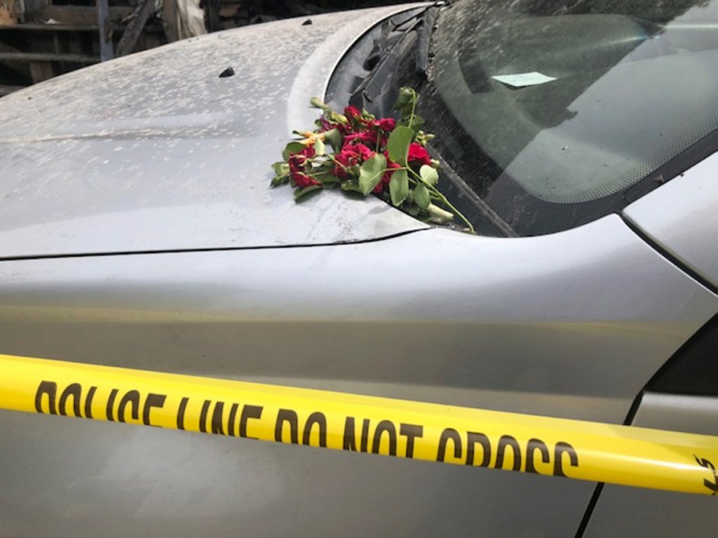 Someone placed a bunch of roses on a car inside the yellow police tape on Milburn Street in Skowhegan, where Douglas Barrett, 48, died in a fire Friday morning.