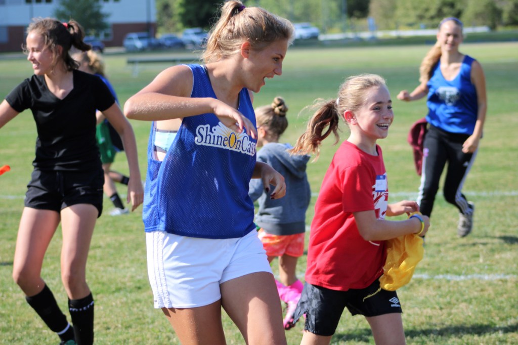 Fourth grader Brielle Dostie, right, keeps pace with Messalonskee soccer player Elena Guarino at ShineOn Saturday on Sept. 8 in Oakland. Guarino, along with her teammates Lydia D'Amico, in back on left and Molly Calkins, in back on right, and the Eagles Girls Soccer team, were part of an annual event to promote youth mentoring and share kindness in memory of former Eagle soccer player Cassidy Charette of Oakland.
