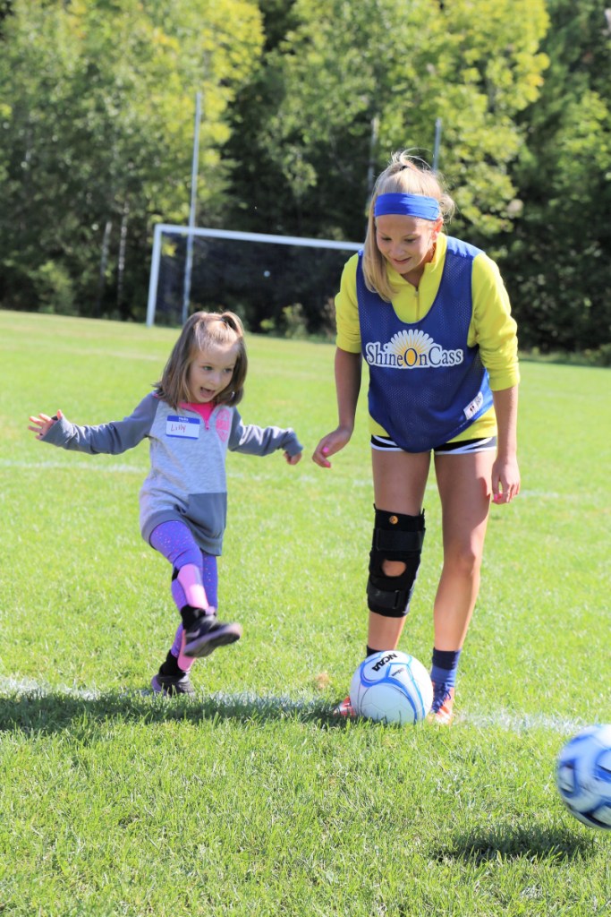 Messalonskee Girls Soccer Team player Lydia Bradfield, right, shares her foot skills with Lillyanne Dyer at ShineOn Saturday, a girls' youth mentoring day created by the ShineOnCass Foundation to honor and remember Cassidy Charette.