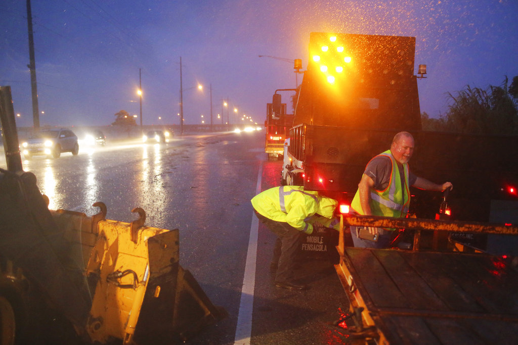 Crew members with the Alabama Department of Transportation work to block off a flooded part of US Highway 98 while fighting rain from Tropical Storm Gordon on Wednesday, in Spanish Fort, Ala. 