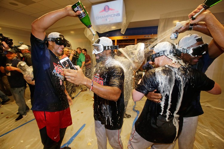 Jackie Bradley Jr., center, William Cuevas, left, and Christian Vazquez, second from right, celebrate after the Red Sox clinched the AL East title with an 11-6 win over the New York Yankees on Thursday night.