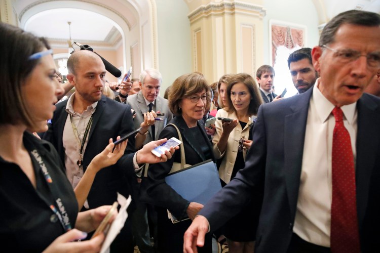 Sen. John Barrasso, R-Wyo., right, leads Sen. Susan Collins, R-Maine, followed by Sen. Rob Portman, R-Ohio, through a crowd of reporters after a Republican lunch meeting on Capitol Hill last week.