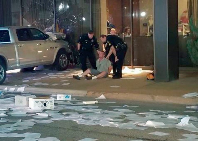In this image taken from video by KDFW Fox 4 a man is detained after crashing his pickup truck into the side of the Fox affiliate television station building in downtown Dallas on Wednesday.