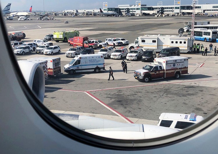 Emergency response crews gather outside a plane at New York's Kennedy Airport amid reports of ill passengers aboard a flight from Dubai on Wednesday.