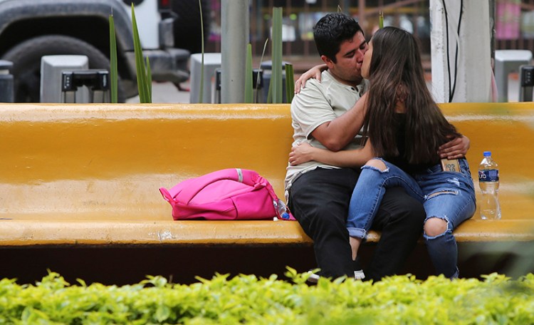 A couple kiss in a public park in Guadalajara, Mexico in August.