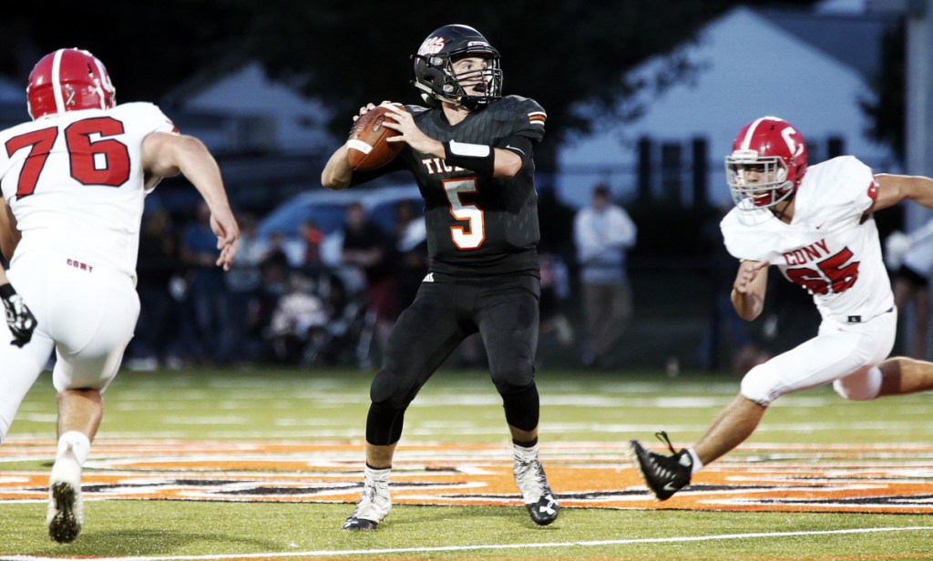 Biddeford quarterback Carter Edgeton feels the pressure from Cony's Nic Mills, left, and Jacob Mills during a September 7 game in Biddeford.