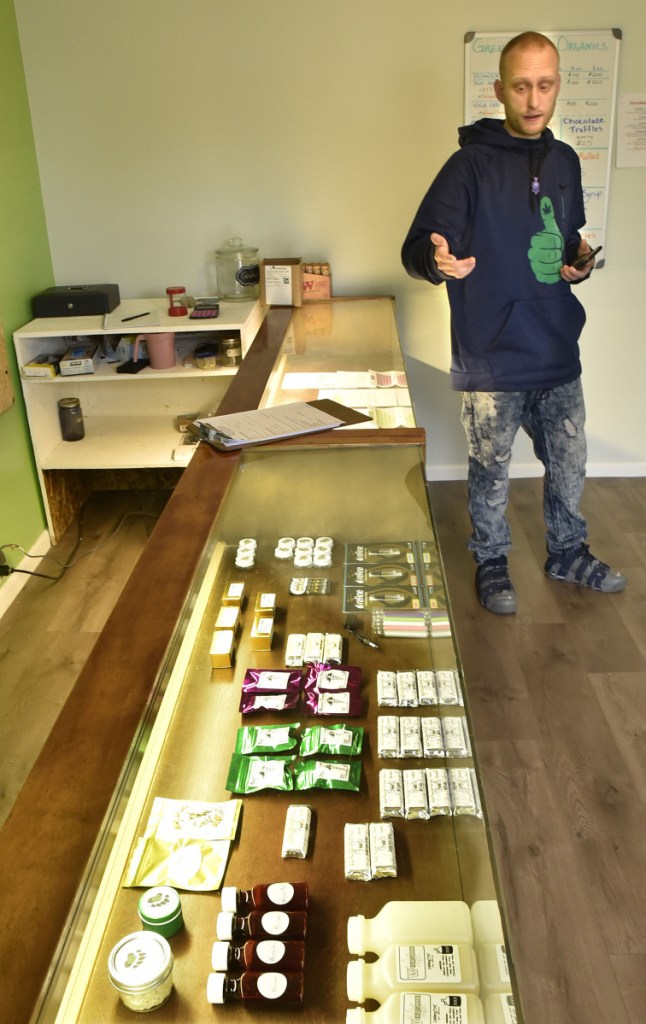 Green Thumb Organics shop owner Dan Hall looks over a display case filled with edible medical marijuana products on Thursday.