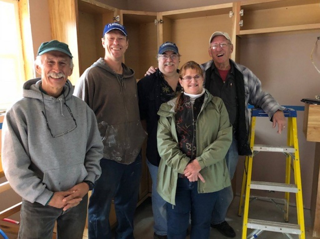 Habitat for Humanity volunteers Mike Grant, Dan Patterson, Dean Dolham and Roland Rancourt stand with Habitat for Humanity & Re-Store Waterville Area executive director Linda Santerre at a house they are building on Clark Street in Waterville.