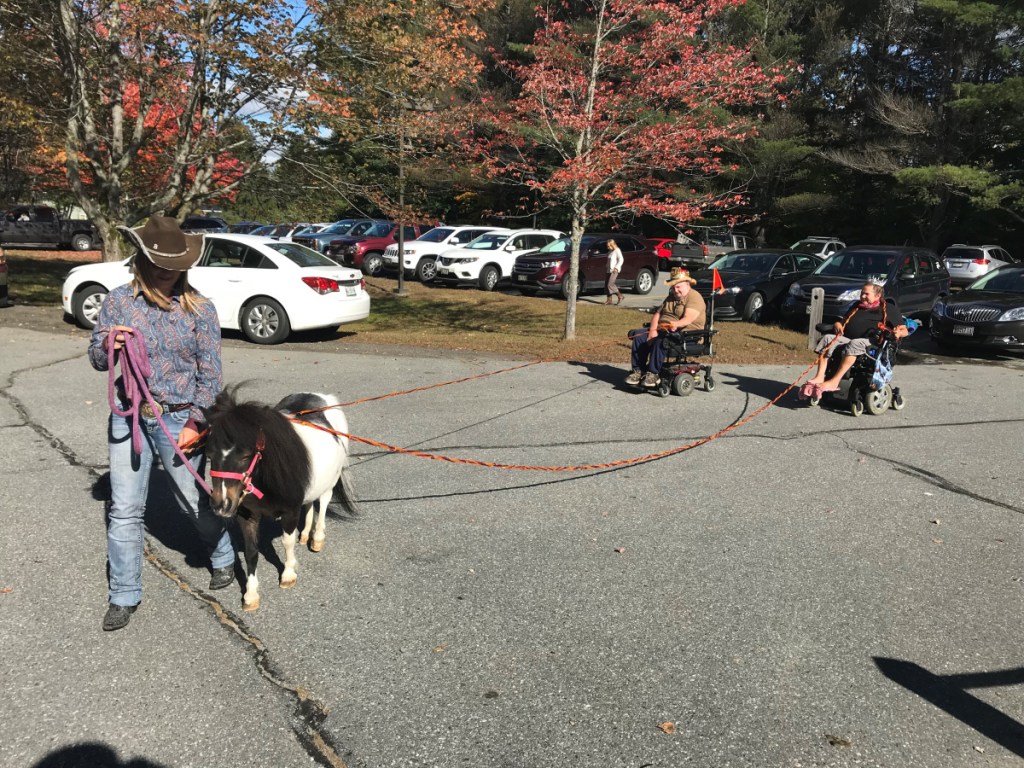 Oreo the horse accompanied by Rebecca Stone, left, escort King Daniel Campbell, center, Queen Gwen Nyholt, right.