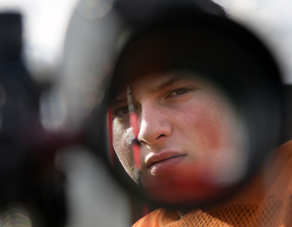 Gardiner Area High School lineman Brad Sandelin looks down the scope of his bow after a practice Wednesday. The varsity football player is also a world champion archer.