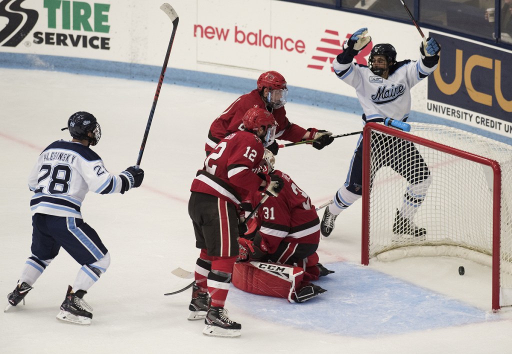 University of Maine's Jack Quinlivan, right, and Adrian Holesinsky, left, celebrate a second period goal by Ryan Smith during a game against St. Lawrence at Alfond Arena in Orono on Friday.