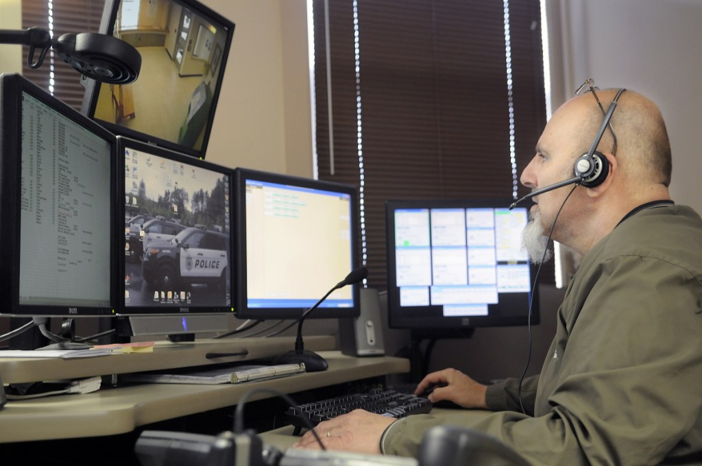 City of Augusta dispatcher Mike Rankins speaks in 2015 with police officers while handling a radio call at the city's emergency communications center.