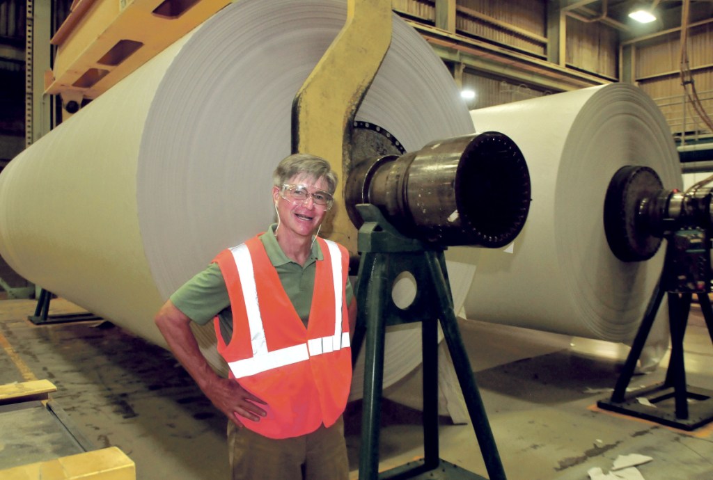 UPM Madison President and CEO Russ Drechsel stands beside two finished rolls of paper in August 2015. The mill closed at the end of May 2016. The paper machine was sold this summer and is being moved to China.