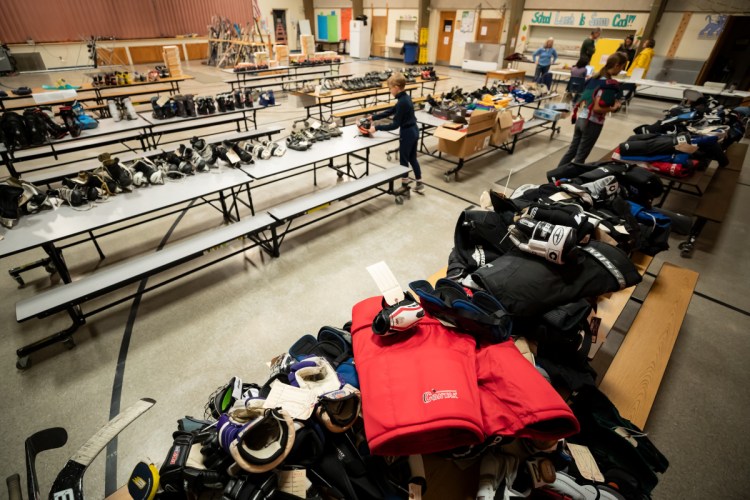 Tables are covered with hockey, alpine skiing and Nordic skiing equipment as part of the Central Maine Ski-Skate Swap on Saturday at the George G. Mitchell School in Waterville.