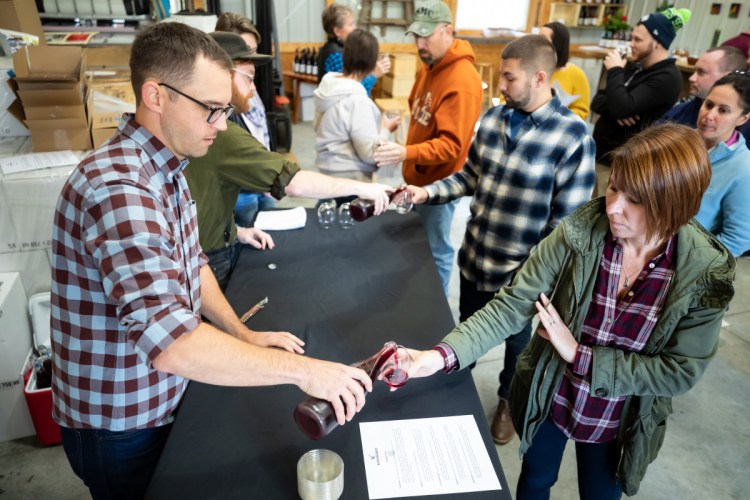 Nathan Hall, left, co-owner of Kennebec Cider Company in Winthrop pours a sample for Briana Dyer, of Sebec, on Saturday afternoon in Winthrop. The tasting event was part of the third annual Ciderfest held at the location.