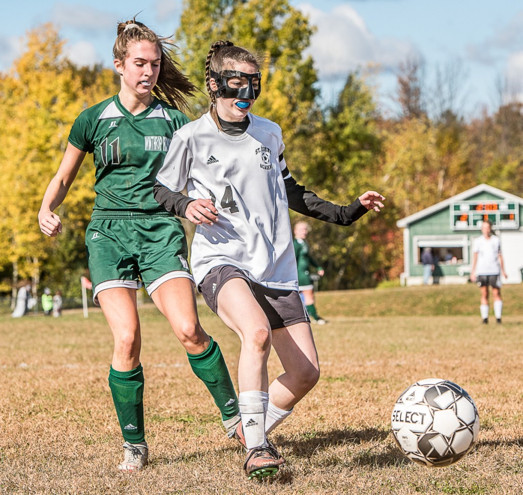 St. Dominic's Raegan Hachey, right, kicks the ball to a teammate and away from Winthrop's Jillian Schmelzer during Saturday's Class C South preliminary game in Winthrop.