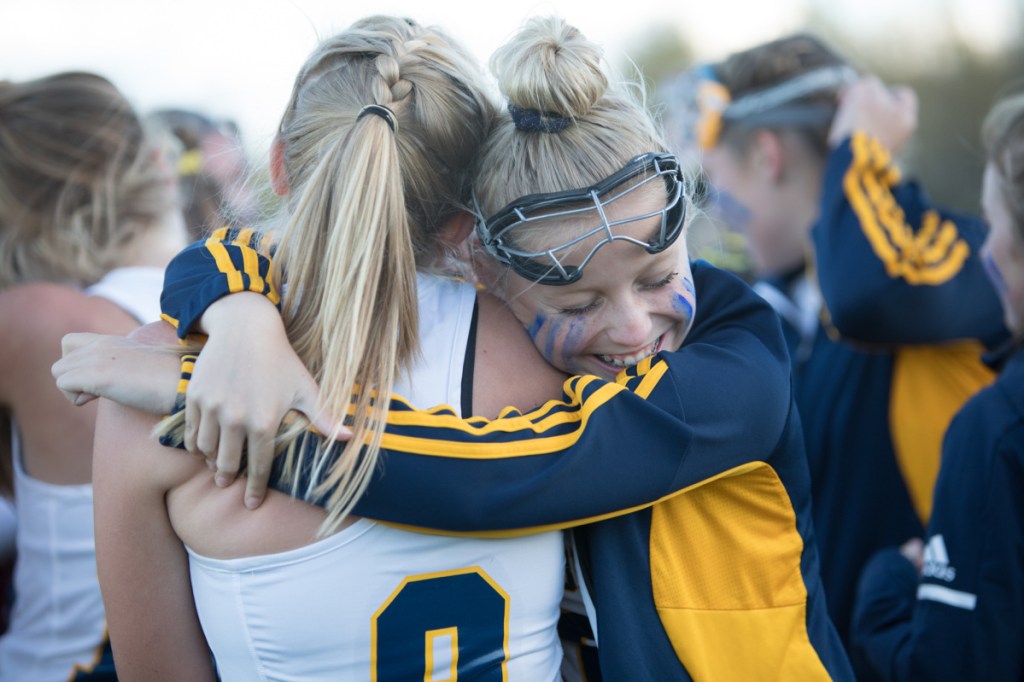 Mt. Blue's Farrah Ballou, right, hugs Bailey Levesque after the Cougars defeated Cony in a Class A North semifinal game Saturday afternoon in Farmington.