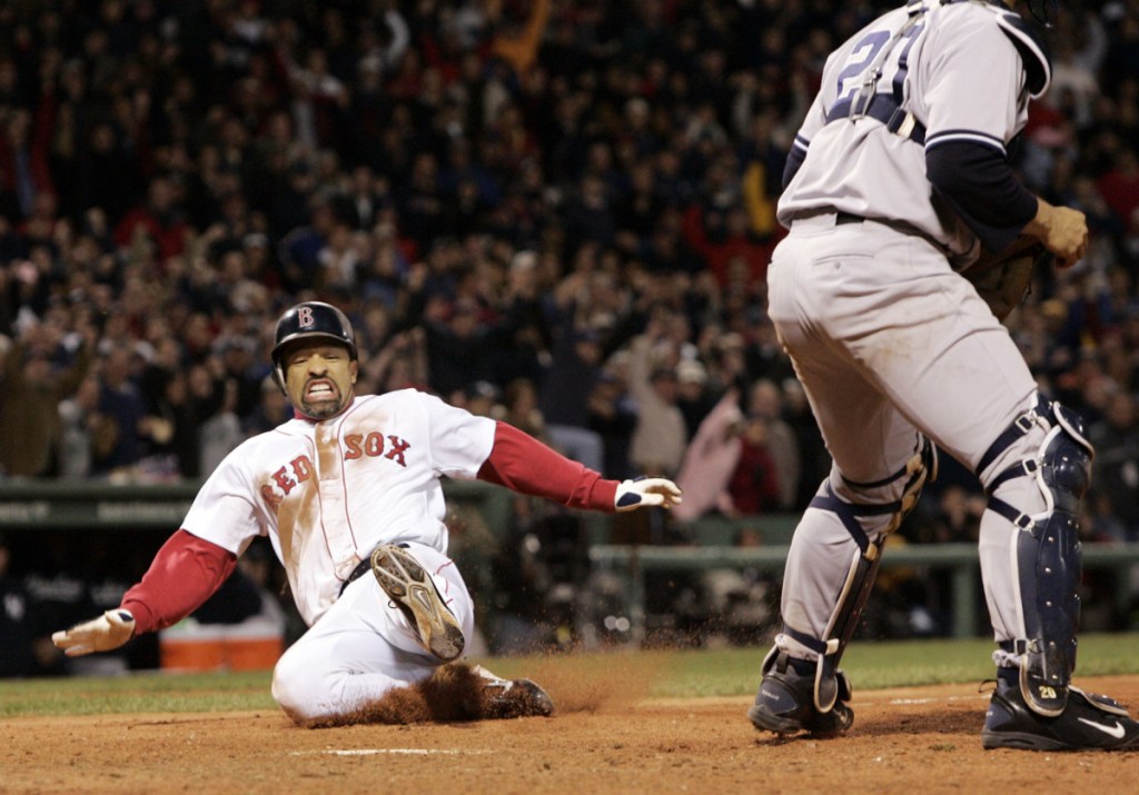 Boston's Dave Roberts, left, slides home to score the tying run past New York Yankees' Mariano Rivera in the ninth inning of Game 4 of the American League Championship Series in October 2004 in Boston. Roberts entered the game as a pinch-runner and came around to score as the Red Sox rallied to defeat the Yankees, come back from a 3-0 deficit in the series and go on to win their first World Series in 86 years. Roberts returns to Fenway Park on Tuesday as the Dodgers manager as Los Angeles faces Boston in the World Series.