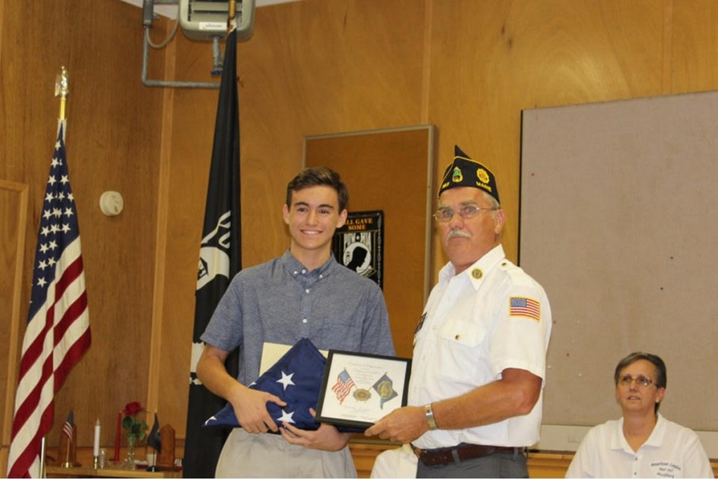 Hagen (Joki) Wallace, left, present an American flag to Commander in Chief is Clayton York during an American Legion and Auxiliary Post 163 special meeting.