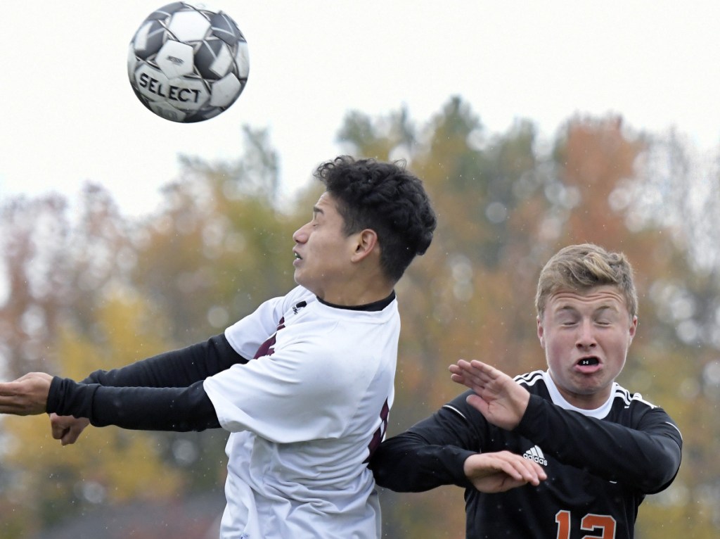 Gardiner's Isaac Gammon, right, heads the ball away from Washington's David Flores during a Class B North quarterfinal game Tuesday in Gardiner.