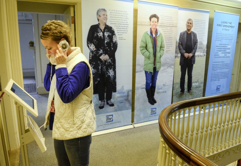 Toni Richardson listens to an interview of herself that's part of a display Tuesday at the First Amendment Museum in Augusta. Richardson, seen on the middle banner in the background, was interviewed about a controversy about religious speech in the workplace while working as an education technician in the Augusta school system.