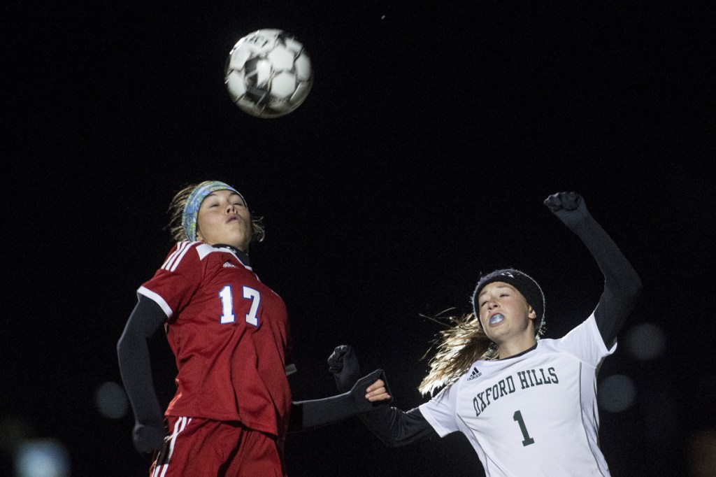 Staff photo by Michael G. Seamans 
 Messalonskee's Edin Sisson, left, battles for a header with Oxford Hills' Bella Divivo during a Class A North quarrerfinal game Tuesday night at Thomas College.