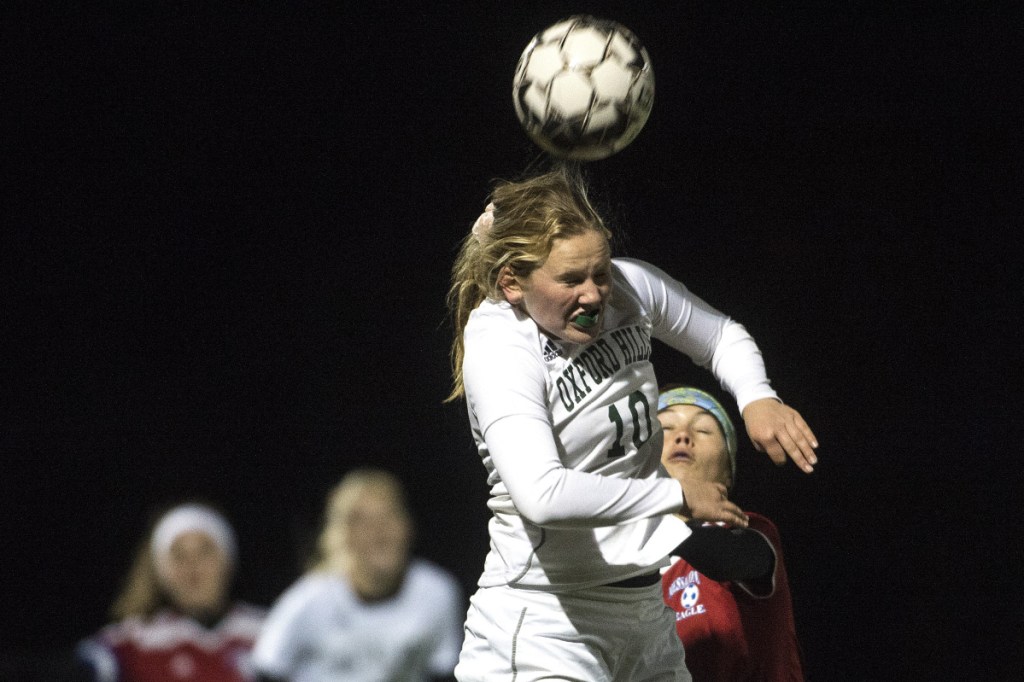 Staff photo by Michael G. Seamans 
 Oxford Hills' Ceceila Diete Rich heads the ball over Messalonskee players during a Class A North quarterfinal game Tuesday night at Thomas College.