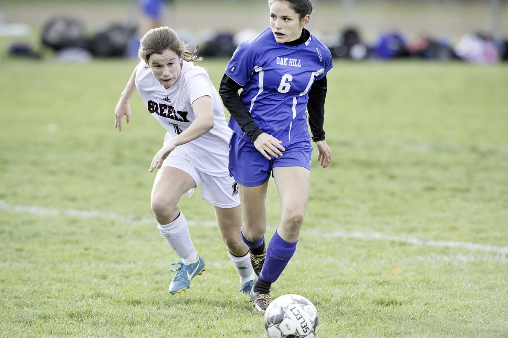 Oak Hill's Gabby Chessie, right, dribbles the ball by Greely's Kerry Roberts during a Class B South quarterfinal game in Wales.