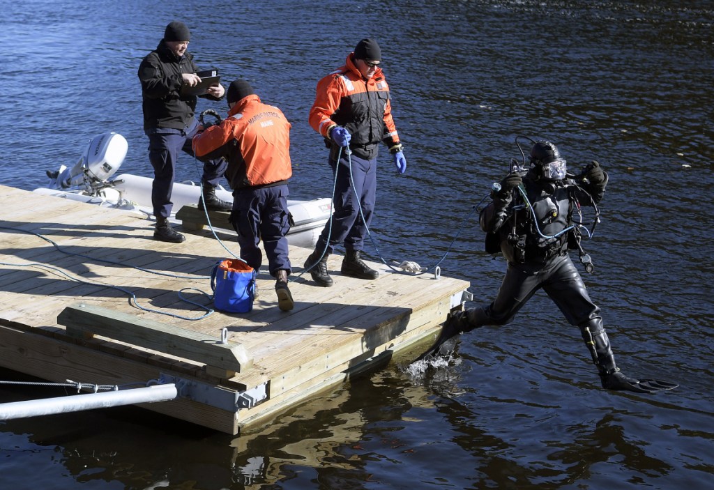 A diver from the Department of Public Safety's dive team leaps off the dock Friday on the Kennebec River in Richmond. Authorities found a body Friday after searching by air, on the water and below the surface for Mark Johnston, 64, who disappeared Thursday night on the river while mooring a boat, police said.