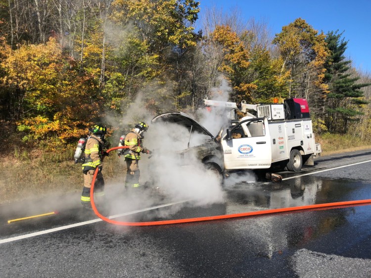 Augusta firefighters extinguish a fire in a heavy equipment service truck Friday on Interstate 95 in Augusta. The fire caused the southbound lanes to be closed briefly in late morning, backing up traffic for at least 3 miles.