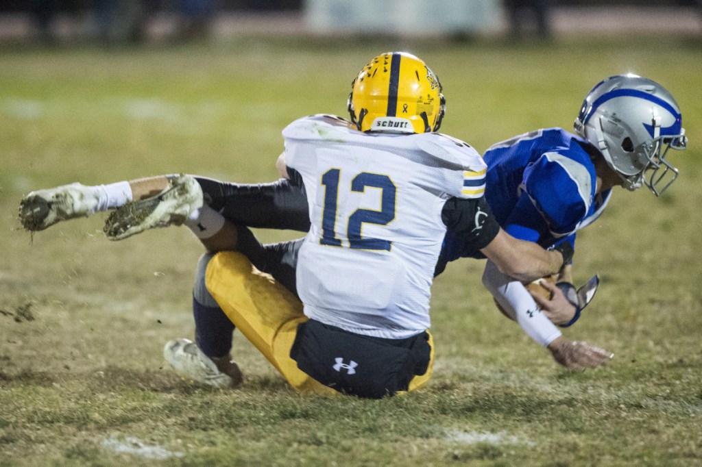 Mt. Blue's Randy Barker tackles Lawrence's Nate Bickford during a Pine Tree Conference Class B quarterfinal round game Friday night at Keyes Field in Fairfield.