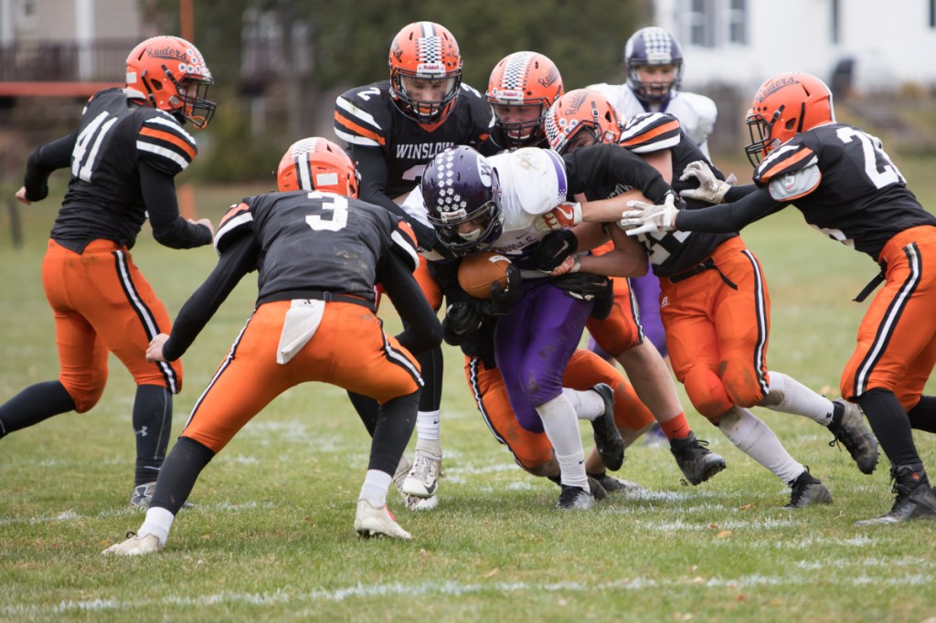 Waterville running back Nicholas Wildhaber draws a crowd of Winslow defenders during a Class C North quarterfinal game Saturday in Winslow.