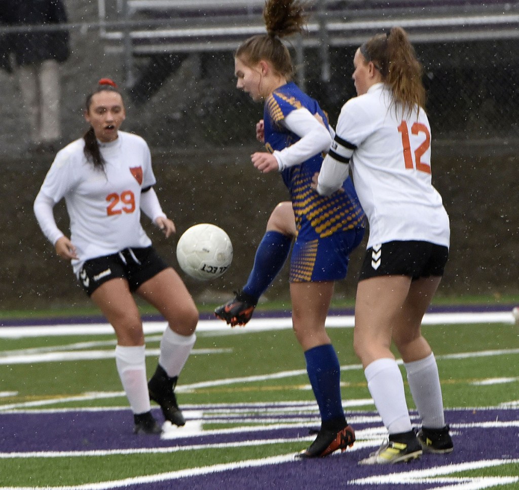Winslow's Desiree Veilleux, left, and Paige Trask pressure Hermon's Sydney Gallop during a Class B North semifinal against Hermon on Monday at Hampden Academy.