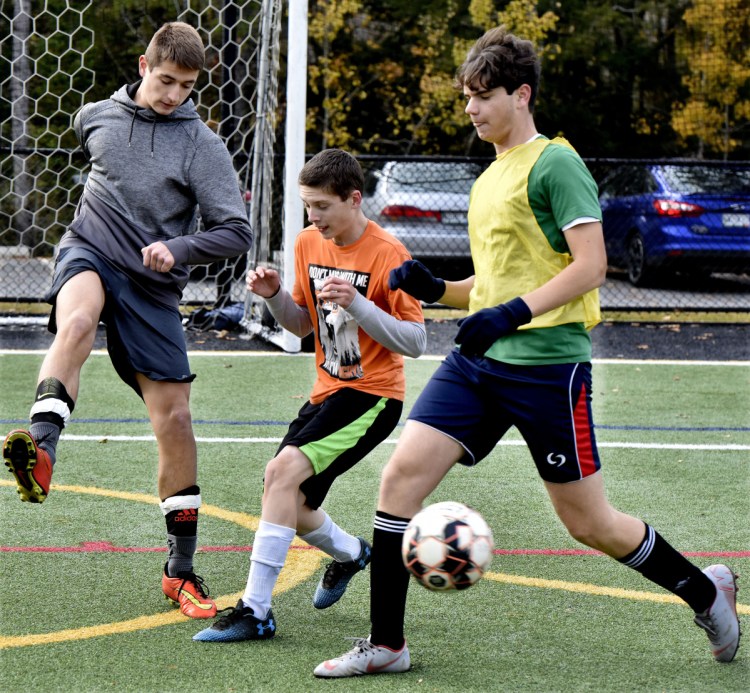 Temple Academy soccer players from left, Steve Kruta, Noah Young and Gian Marco Rossi compete in practice Tuesday in Waterville. The team will play today in the regional final game against North Yarmouth Academy.