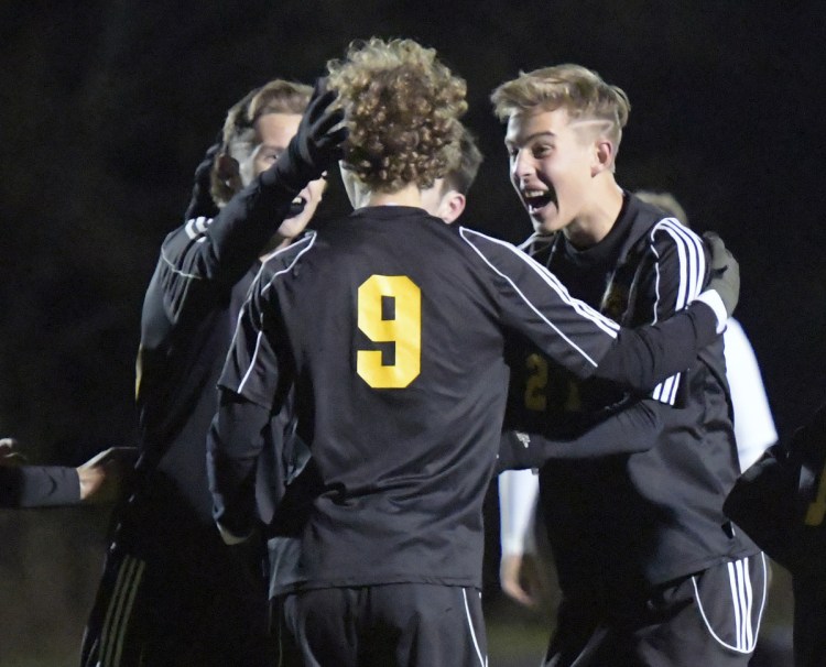 Maranacook's Richard Down (9) is congratulated by teammates after scoring a goal against Winthrop during a Class C South quarterfinal game last week in Readfield.