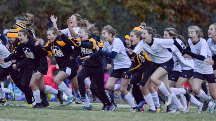 The Maranacook girls soccer team runs onto the field to celebrate after beating Traip Academy in the Class C South regional final Wednesday in Kittery.