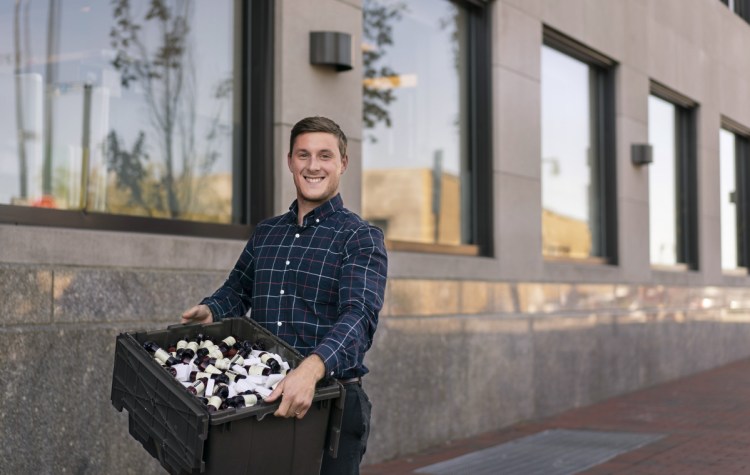 Tristan Corriveau with a bin of leftover soap outside of the Press Hotel in Portland on Monday.