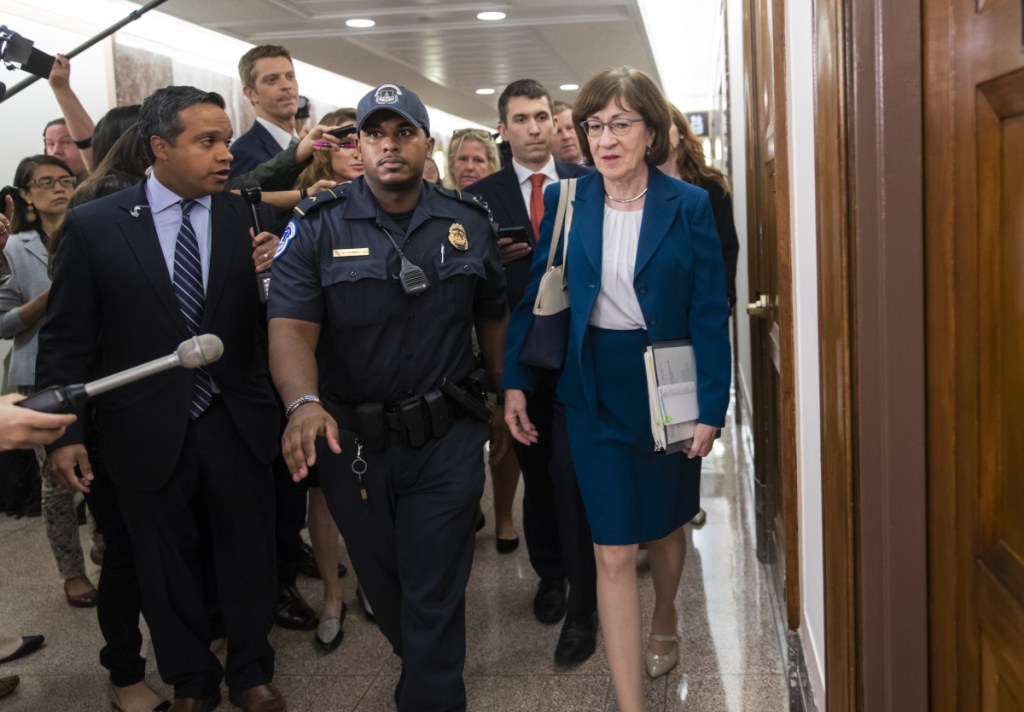 Sen. Susan Collins, R-Maine, is escorted by U.S. Capitol Police as she is met by cameras and reporters asking about embattled Supreme Court nominee Brett Kavanaugh, on Capitol Hill in Washington on Wednesday. Collins was arriving to chair the Senate Special Committee on Aging.
