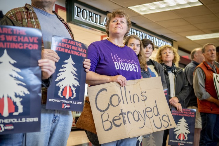 Cecelia Corey of Clinton holds a sign during a We Believe Survivors rally Sunday at the Portland International Jetport. About 50 people showed up at the noontime protest against Sen. Susan Collins.