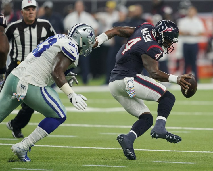 Houston quarterback Deshaun Watson is pressured by Dallas defensive tackle Daniel Ross on Sunday in Houston. The Texans beat the Cowboys, 19-16 in overtime.