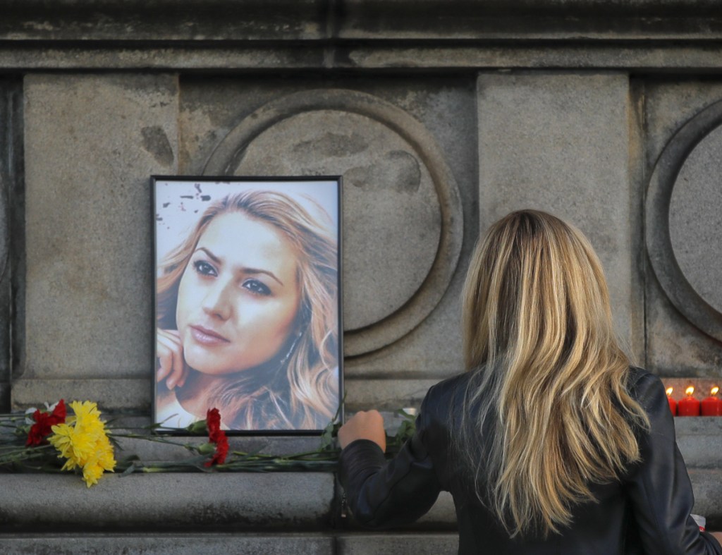 A woman places flowers next to a portrait of slain TV reporter Viktoria Marinova in Ruse, Bulgaria, Monday.