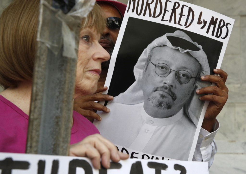 Protesters demonstrate outside the Saudi Embassy in Washington on Wednesday. The U.S. is demanding answers to the suspected assassination of Saudi journalist Jamal Khashoggi, pictured, President Trump says.