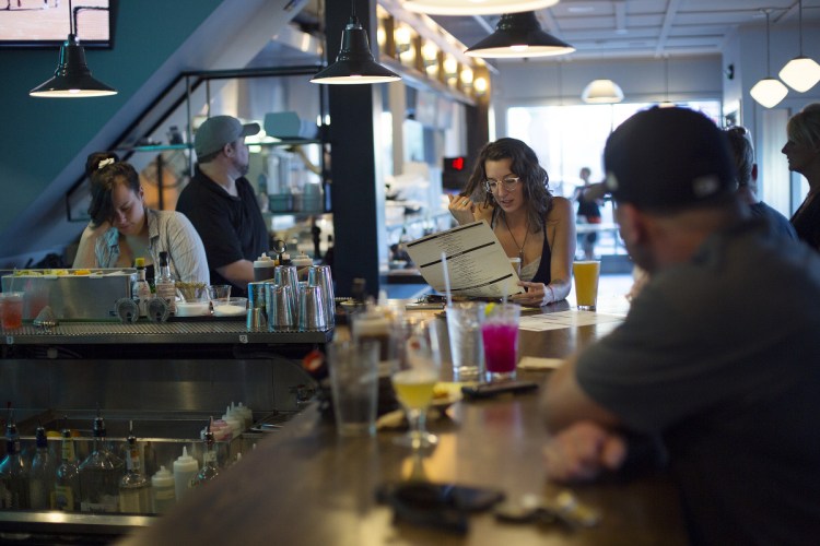 Danielle Gismondi of Portland looks over the menu at the bar at Elsmere's new Portland location.