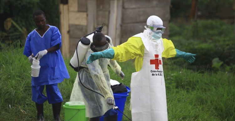 A health worker sprays disinfectant on his colleague after working at an Ebola treatment center in Beni, Congo, on Sept. 9. Nearly 100 people have died from the virus.