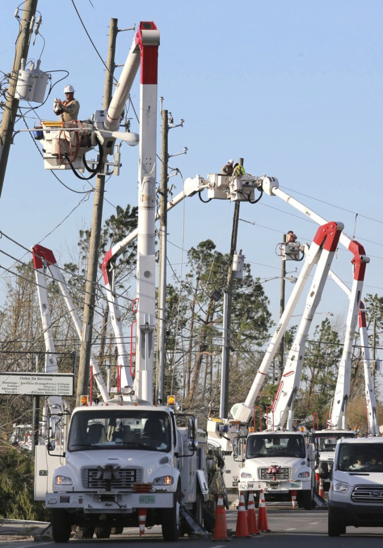 Gulf Power crews line the street in Panama City, Fla., on Friday as they try to restore power after tens of thousands were left without electricity by Hurricane Michael.
