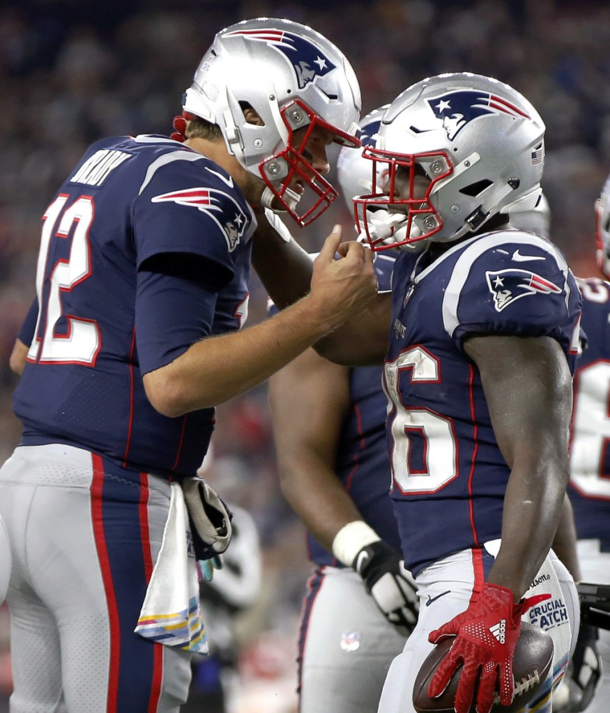 New England Patriots quarterback Tom Brady, left, congratulates running back Sony Michel after Michel scored Sunday night in the first half of the home game against the Kansas City Chiefs. New England won, 43-40.