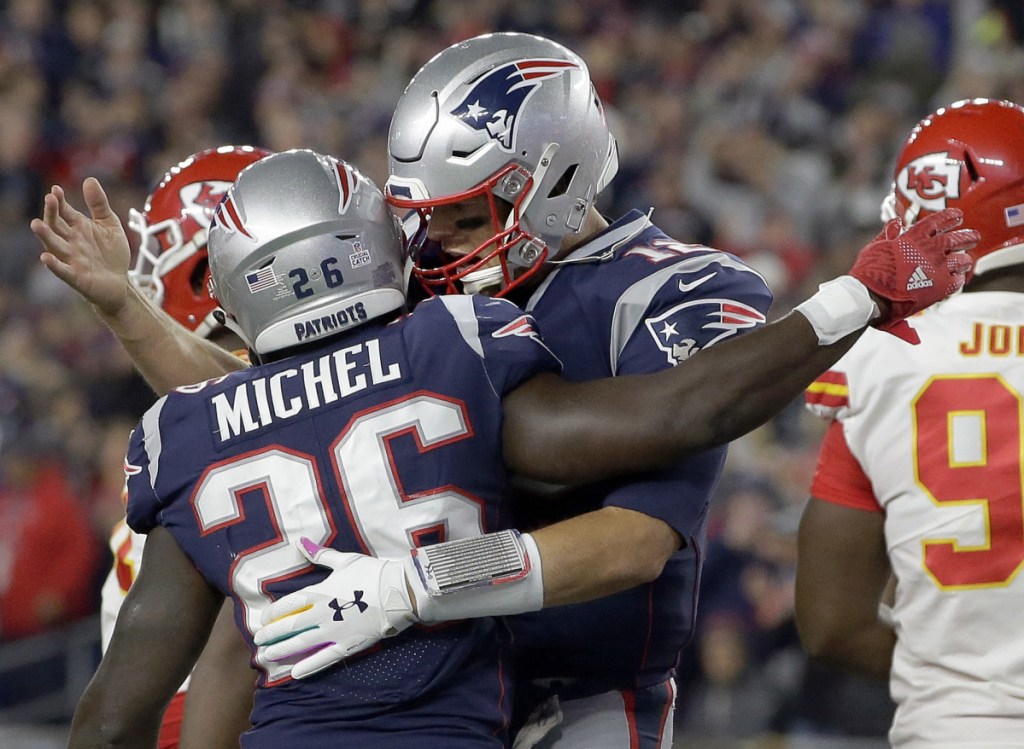 New England Patriots quarterback Tom Brady, right, celebrates a rushing touchdown by running back Sony Michel in the first half Sunday night. The Patriots beat the Chiefs, 43-40.